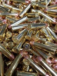 Loose 38 Special pistol ammo in a pile with shiny clean brass.